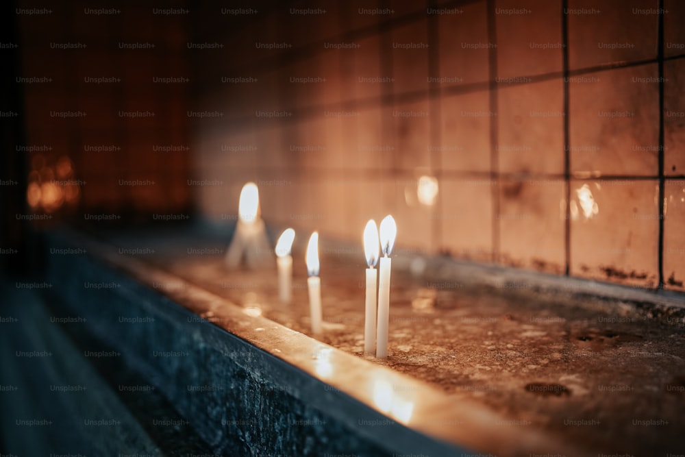 uma fileira de velas sentadas em cima de um balcão