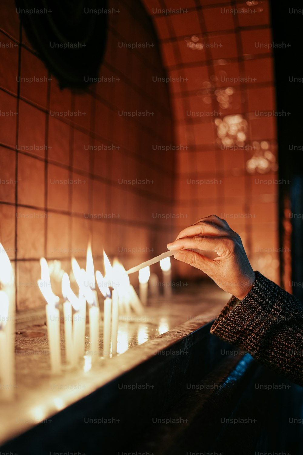 Una persona encendiendo velas en una iglesia