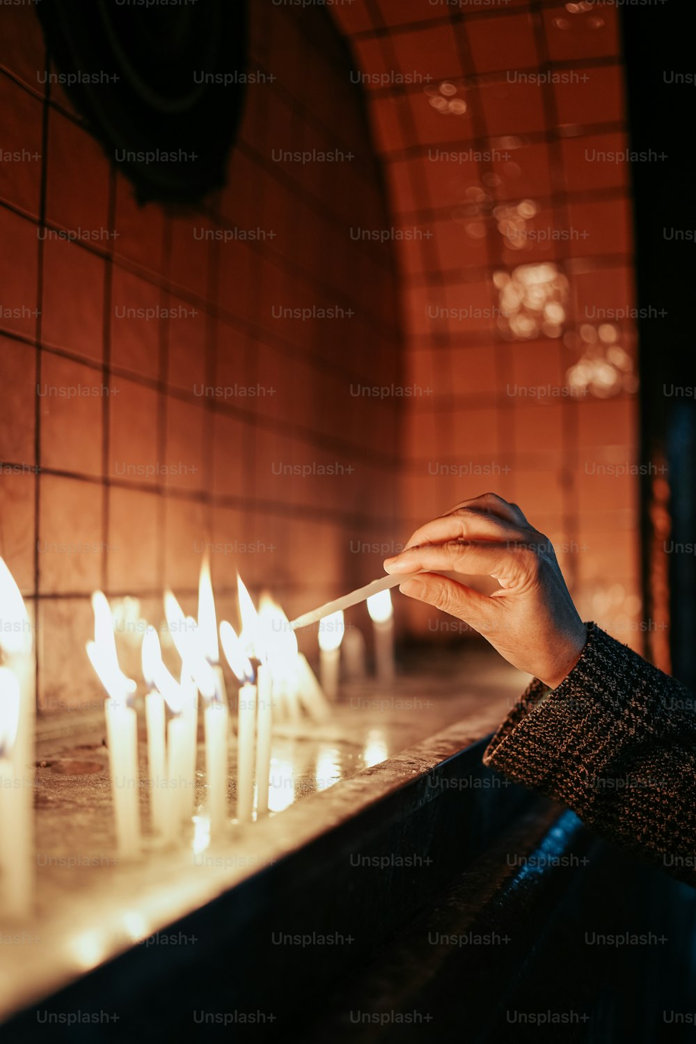 a person lighting candles in a church