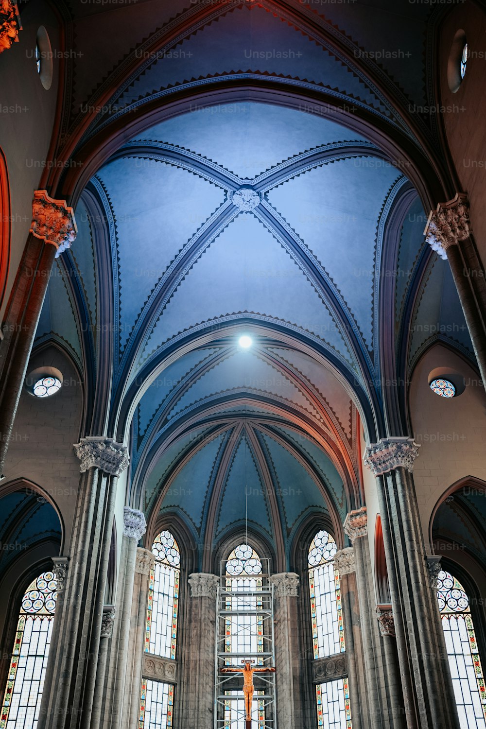 高いアーチ型の天井とステンドグラスの窓がある大きな大聖堂