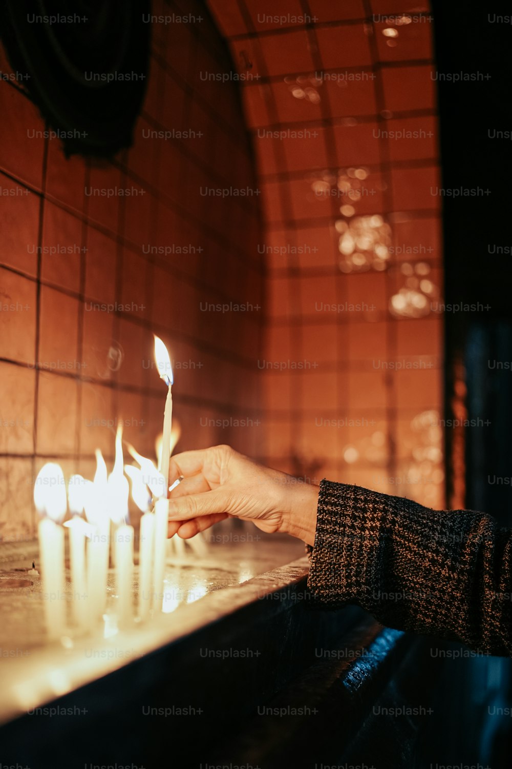 a person lighting a candle in a church