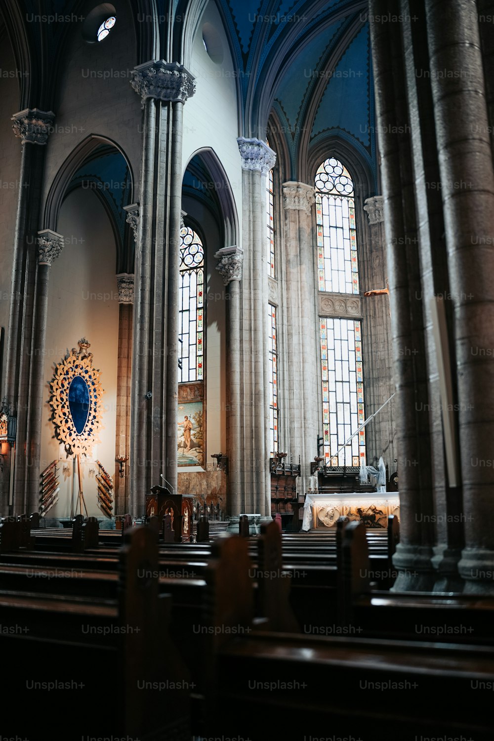 das Innere einer Kirche mit Bänken und Buntglasfenstern