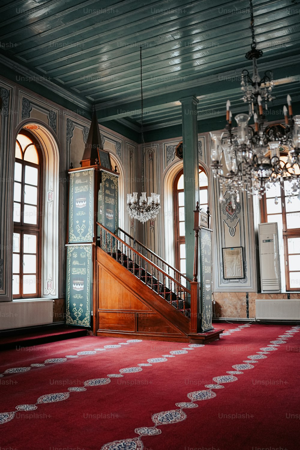 a large room with a red carpet and chandelier