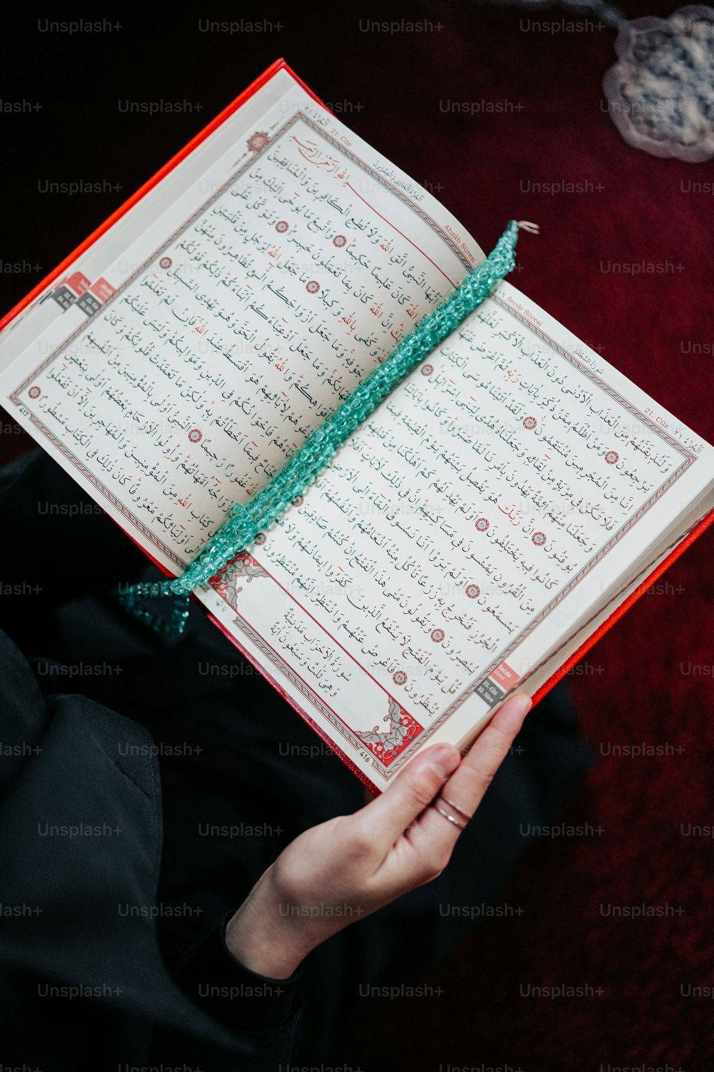 une personne tenant un livre ouvert avec des écrits en arabe dessus