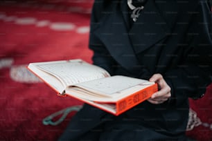 a person sitting on a rug holding a book