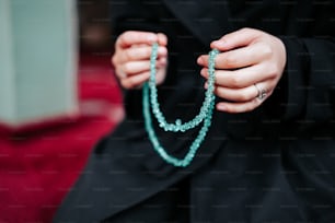 a woman is holding a rosary in her hands