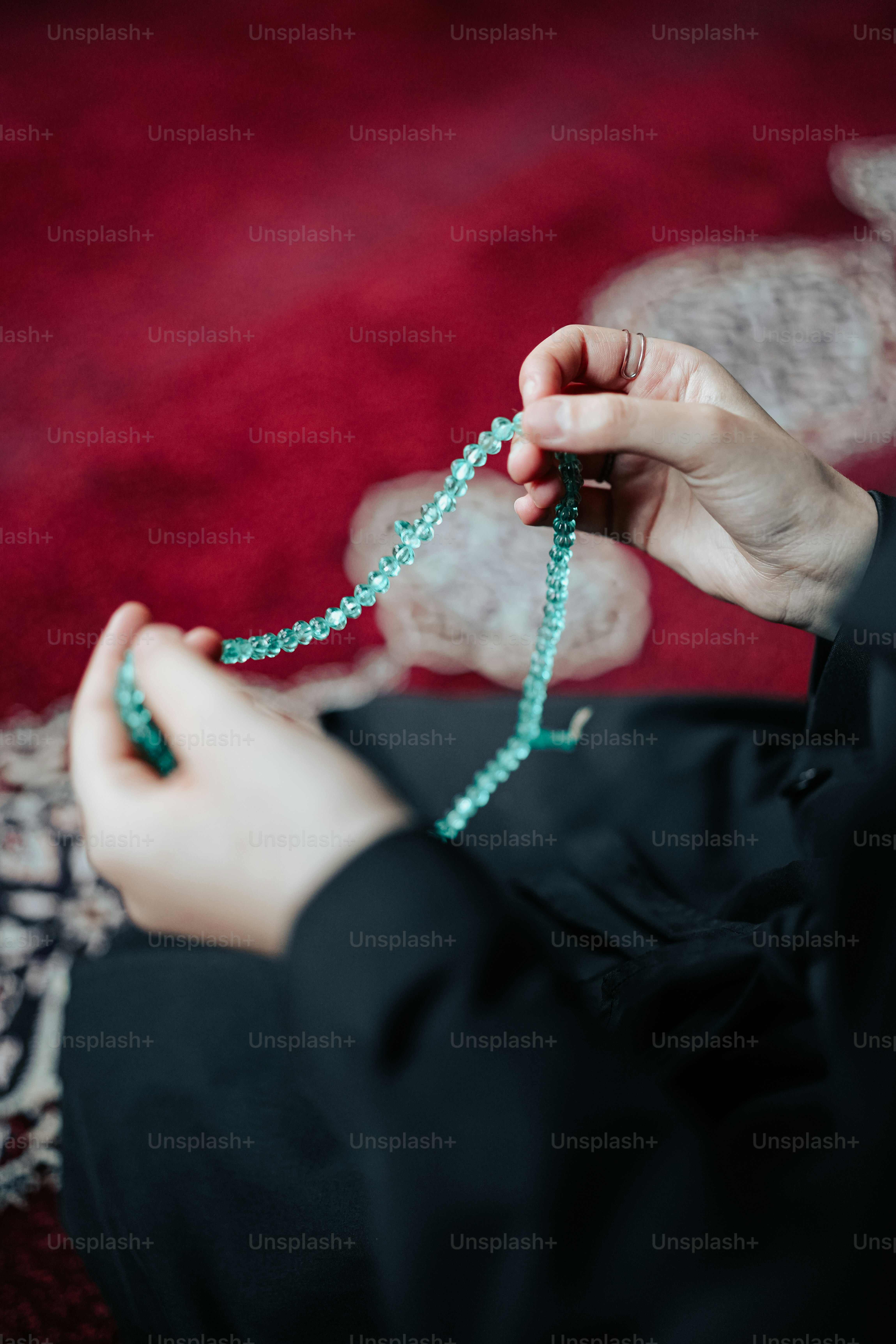 a woman is holding a string of beads