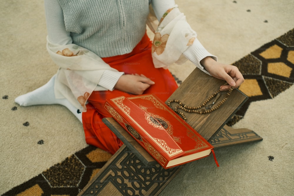 a woman sitting on the floor holding a book