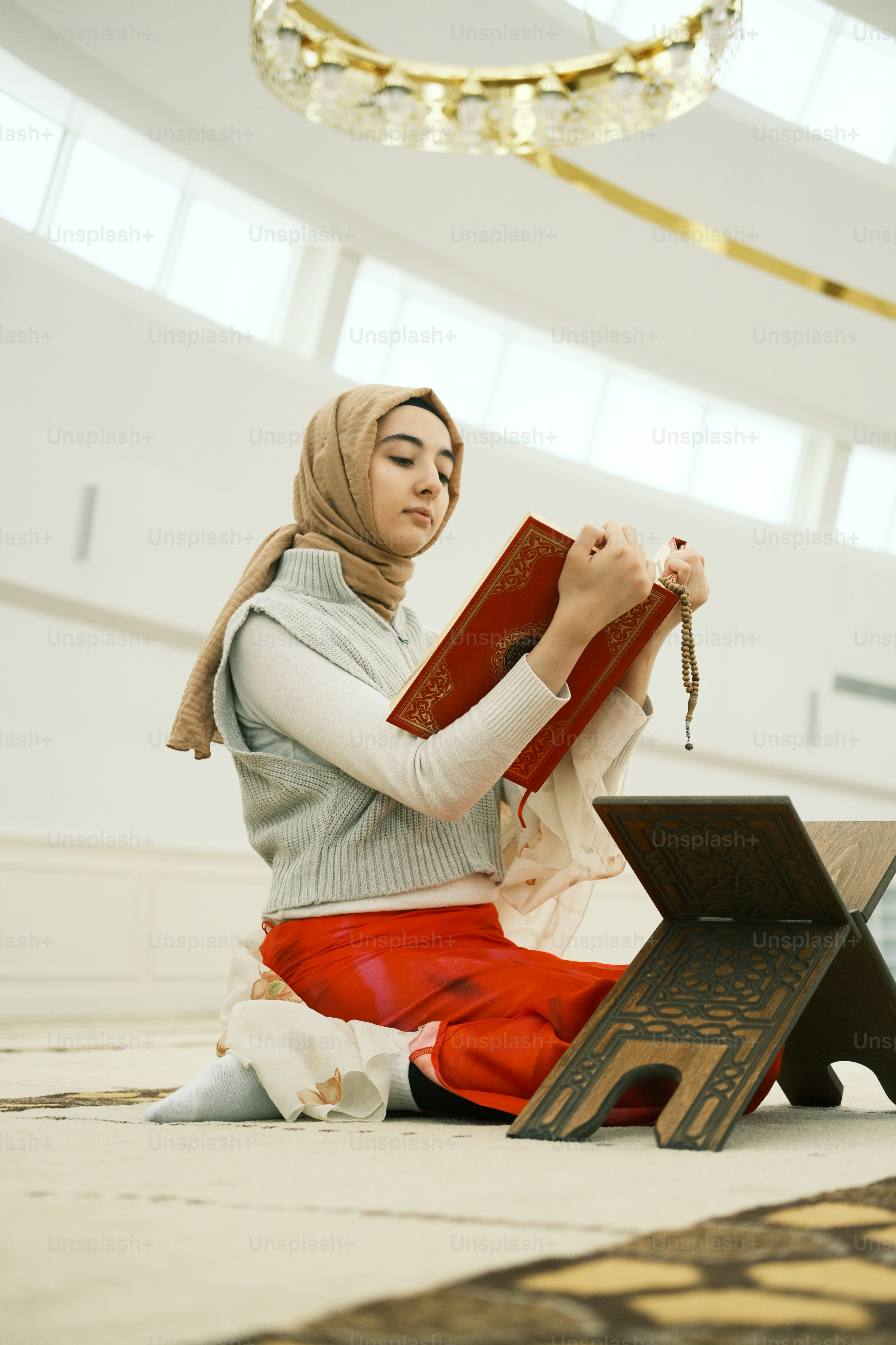 seorang wanita duduk di lantai membaca buku