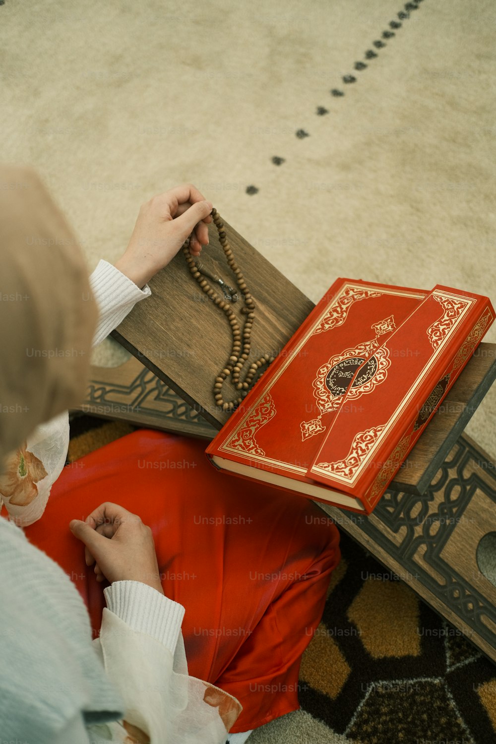 Una mujer sentada en el suelo con un libro en su regazo