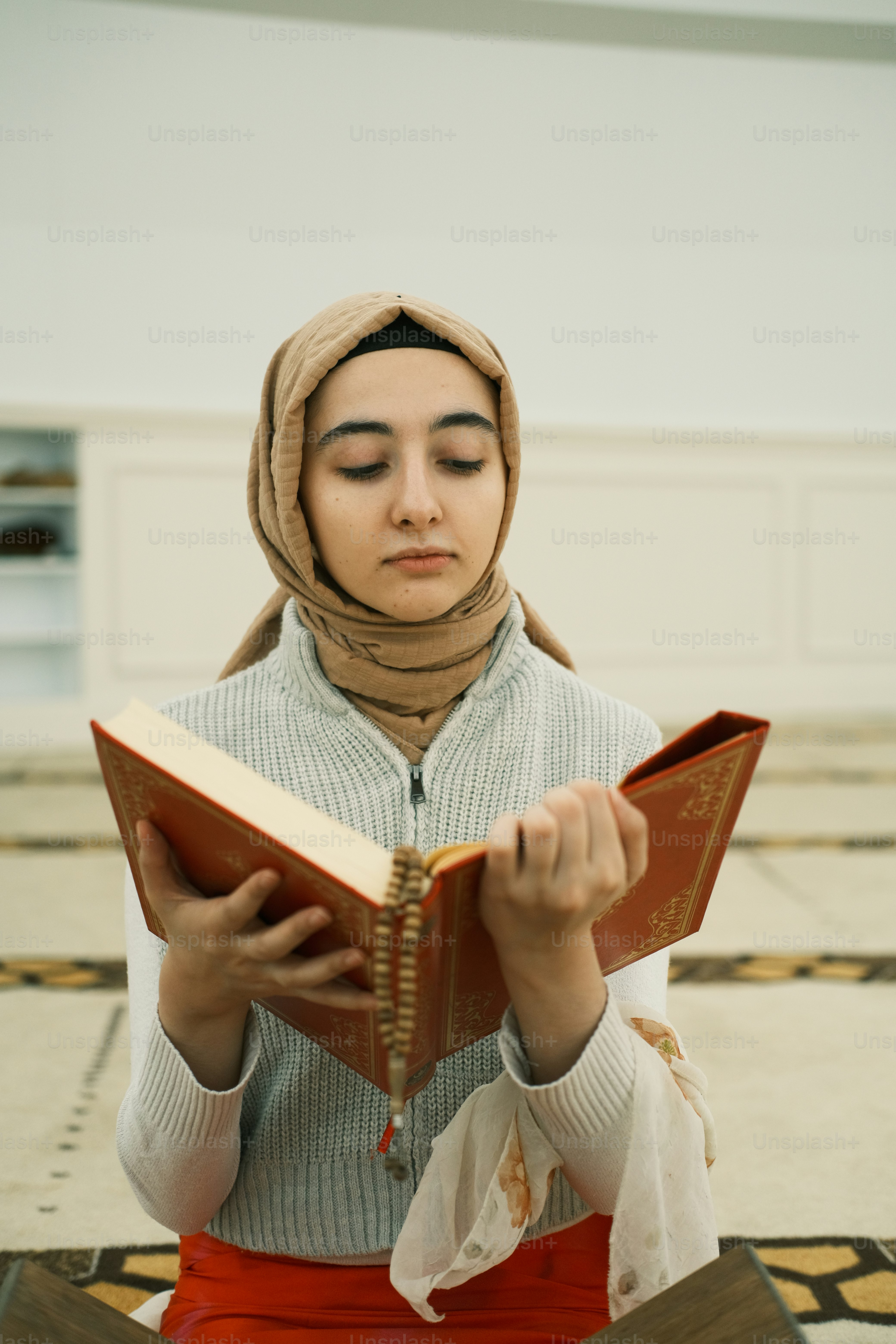 a woman sitting on the floor reading a book