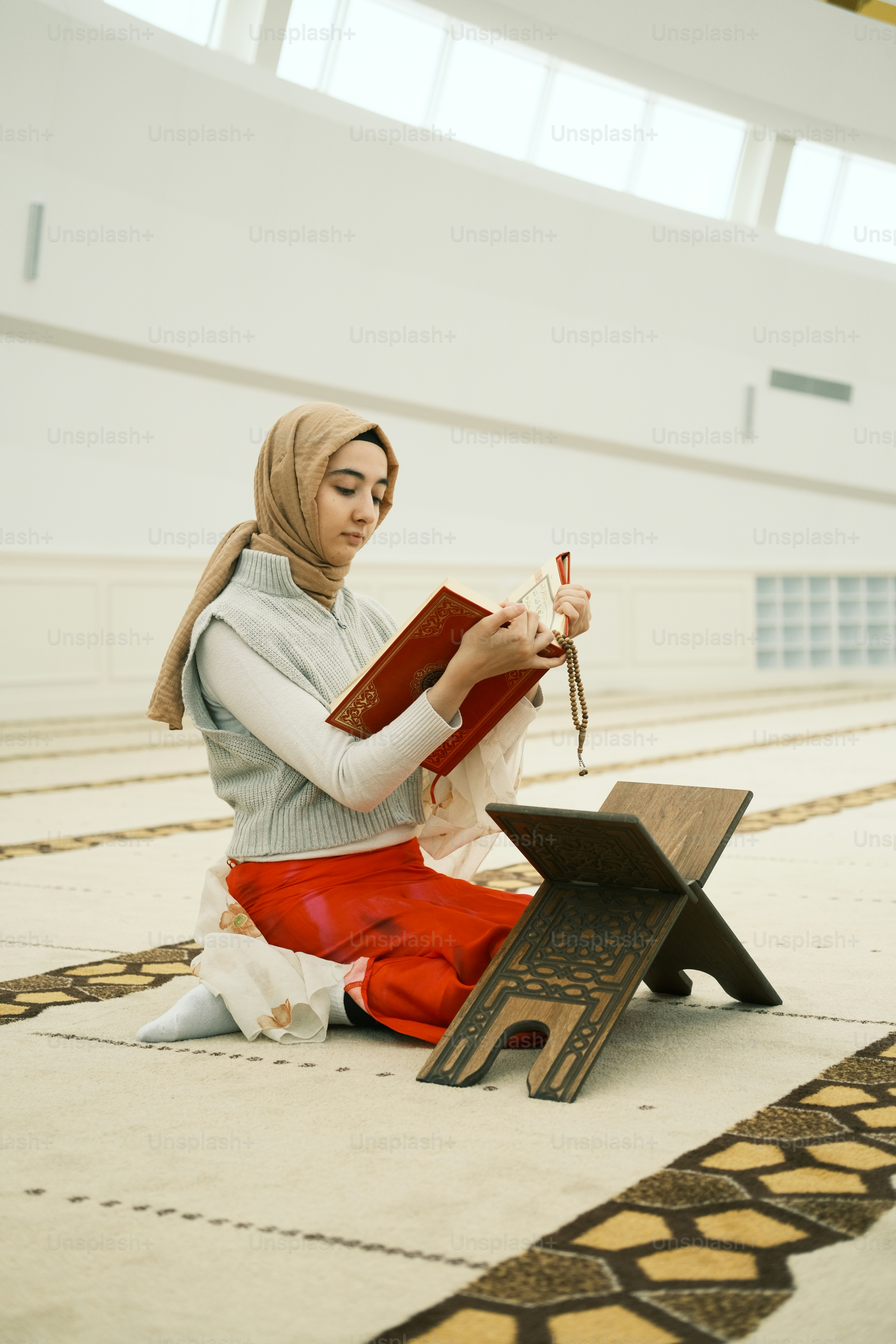 A woman sitting on the floor reading a book photo – Mecca mosque Image ...