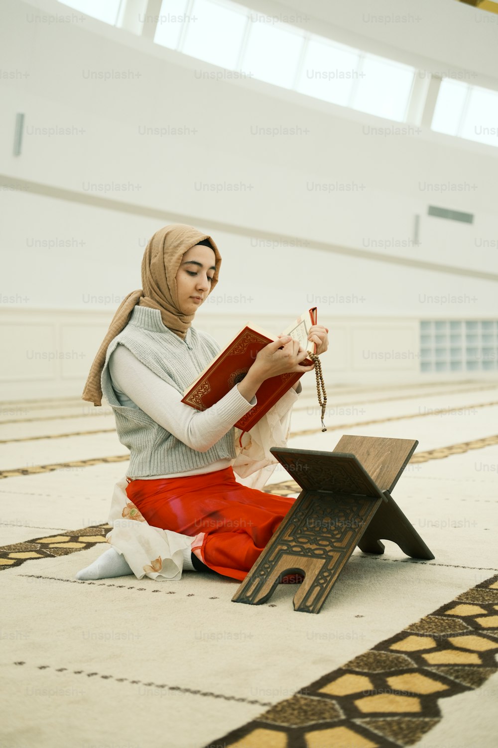 uma mulher sentada no chão lendo um livro
