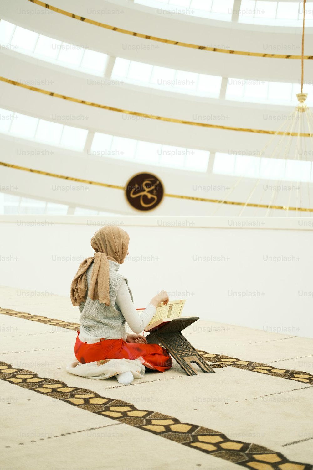 a woman sitting on the floor reading a book