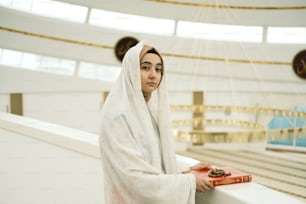 a woman in a white shawl holding a box of cookies