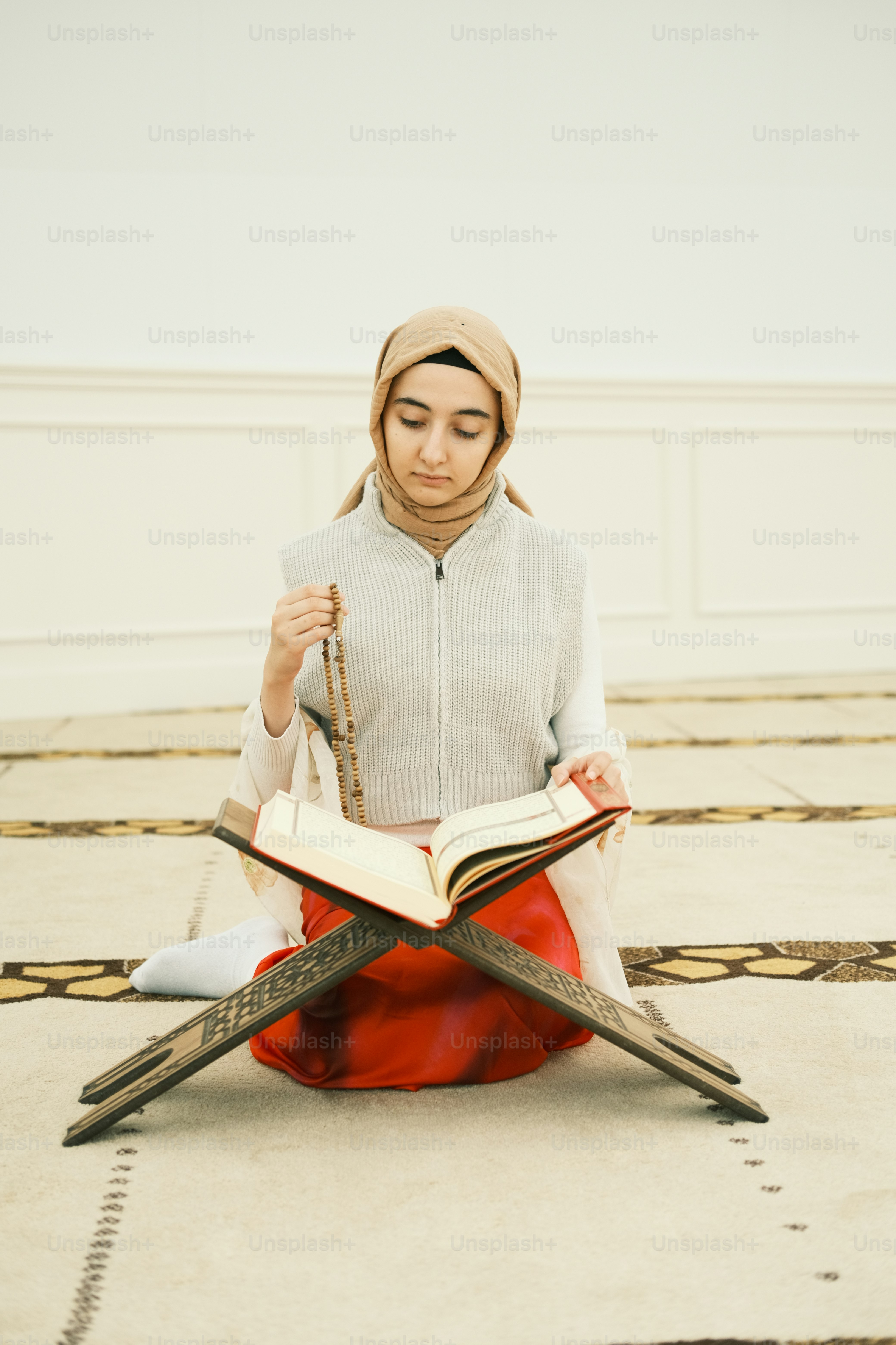 a woman sitting on the floor reading a book