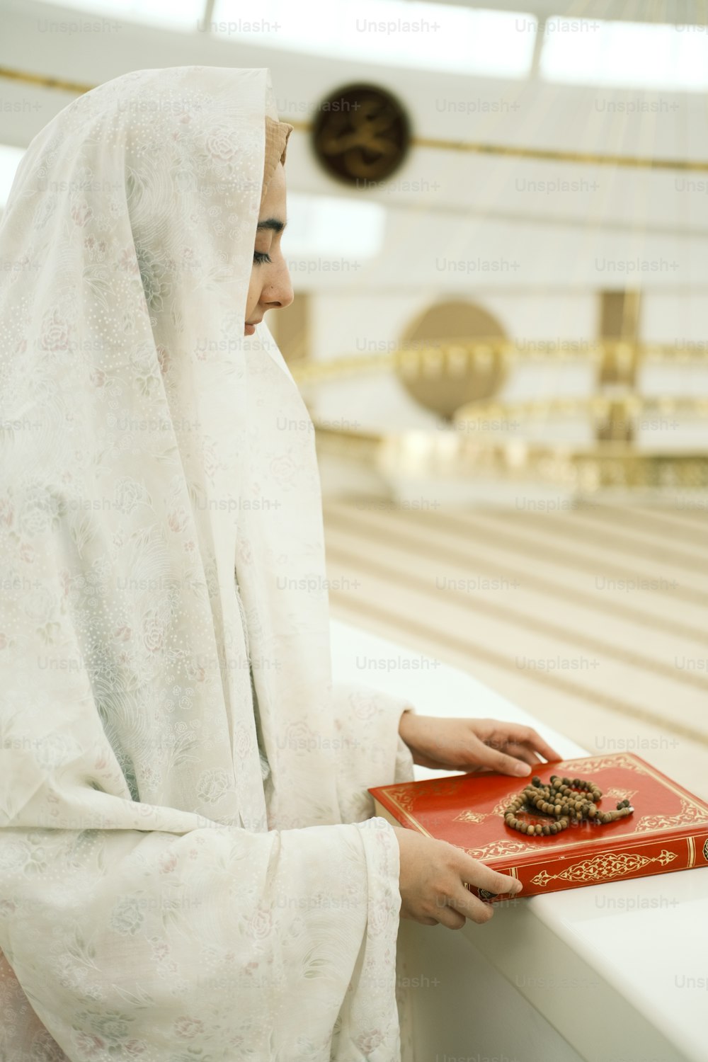 a woman in a hijab is holding a book