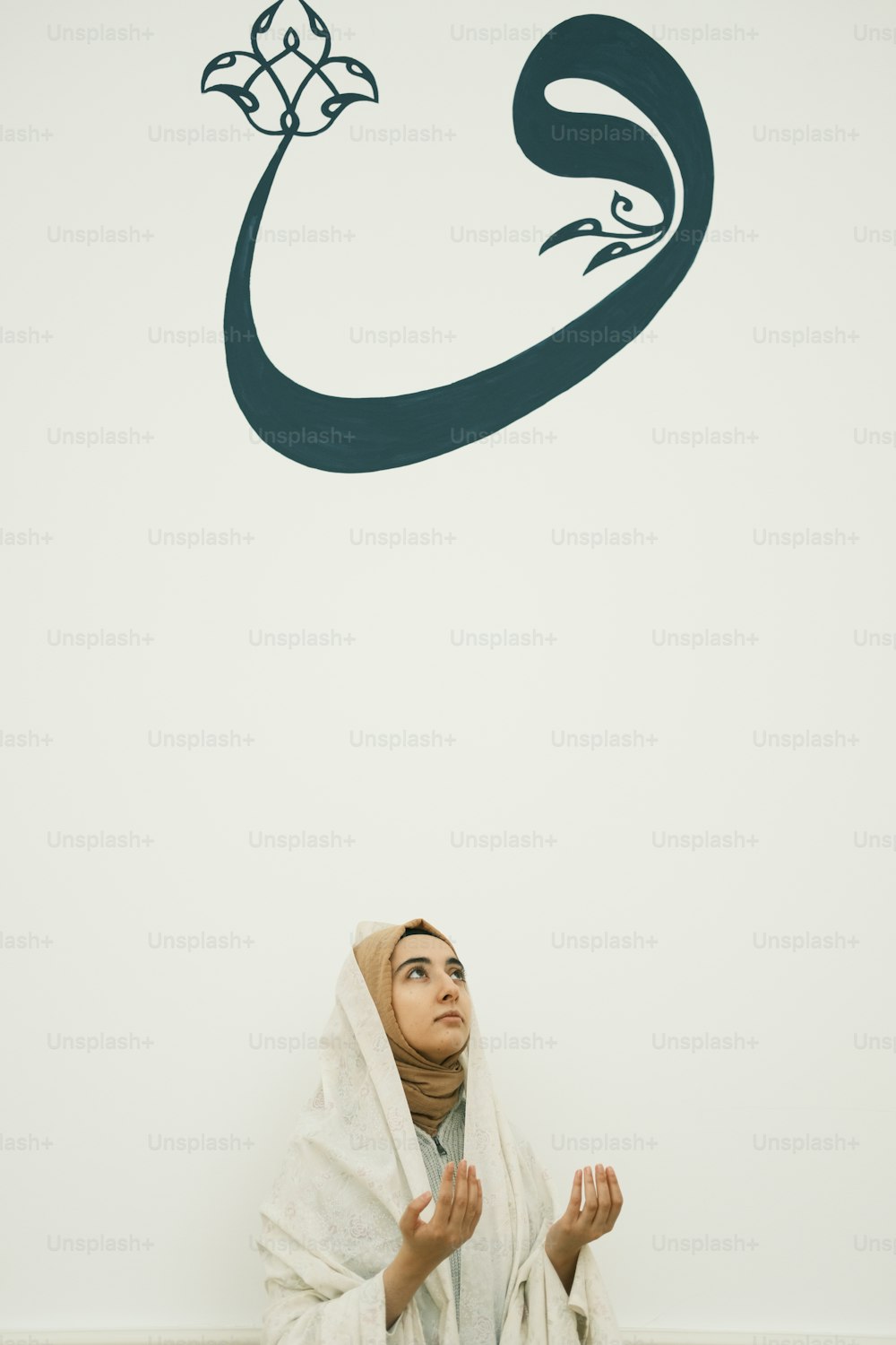 a woman sitting on the floor in front of a wall