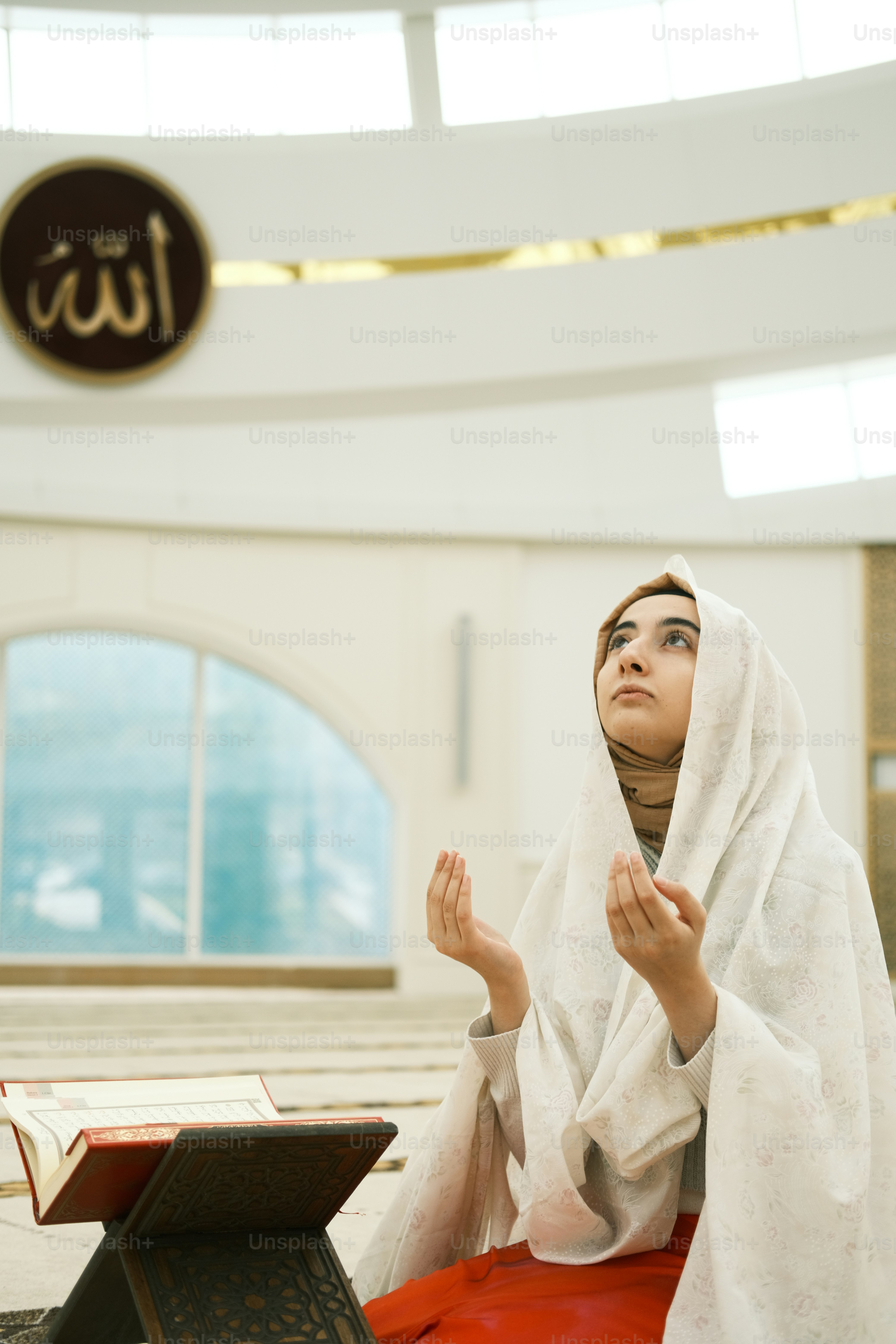 a woman sitting on the floor with her hands folded in prayer