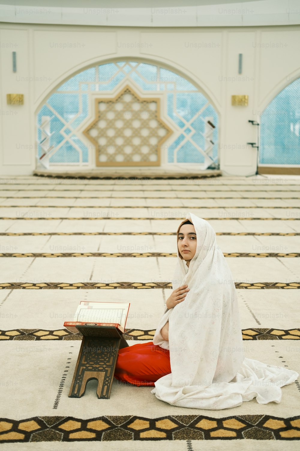 a woman sitting on the floor with a book