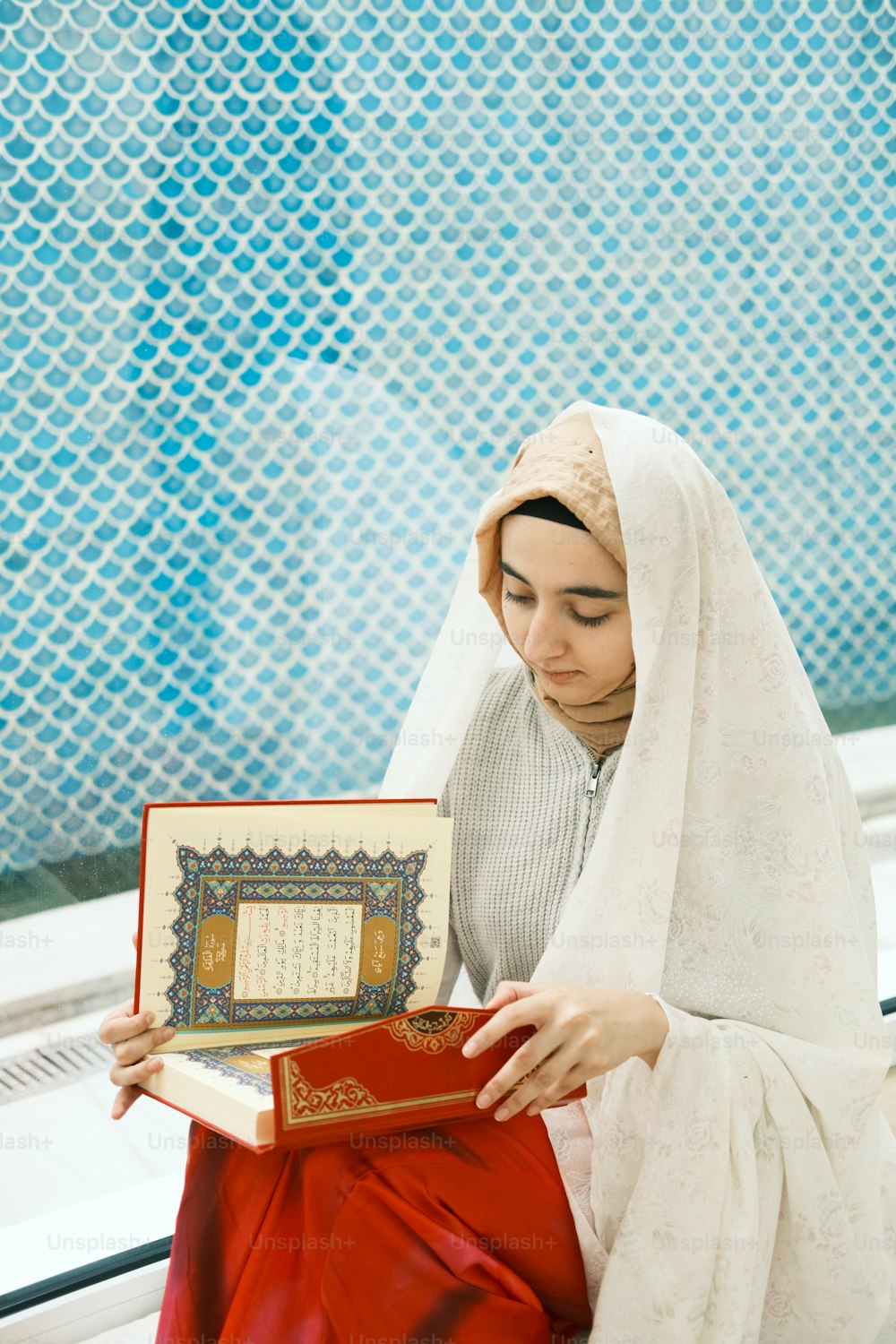 a woman sitting on a bench holding a book