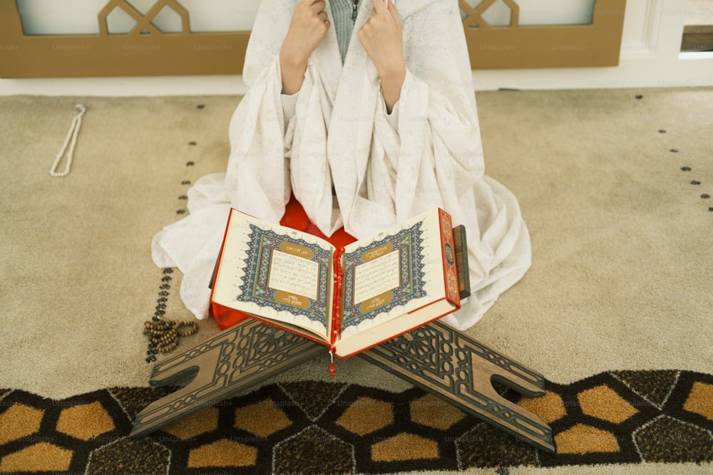 a person sitting on the floor with a book
