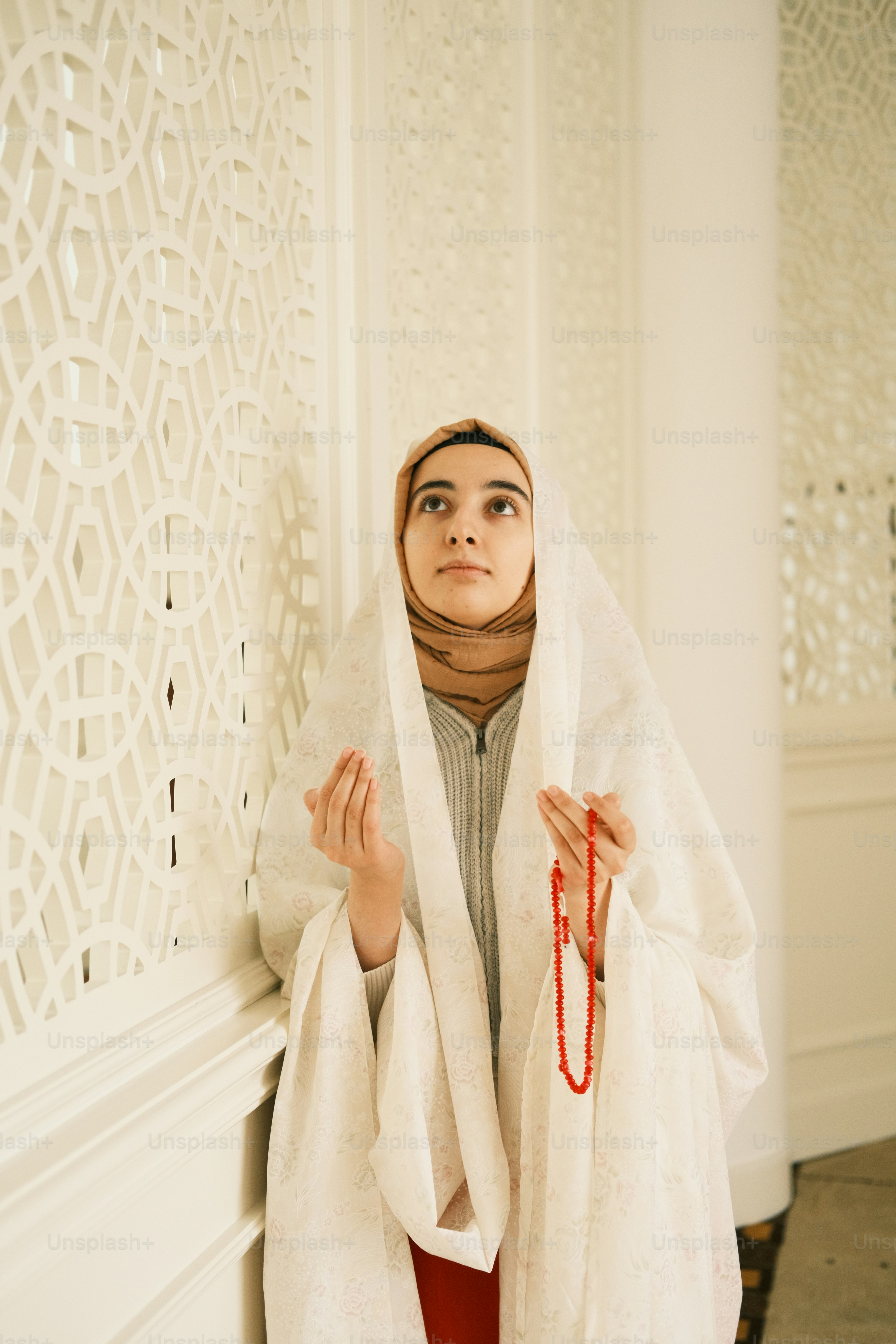a woman wearing a white shawl and red pants