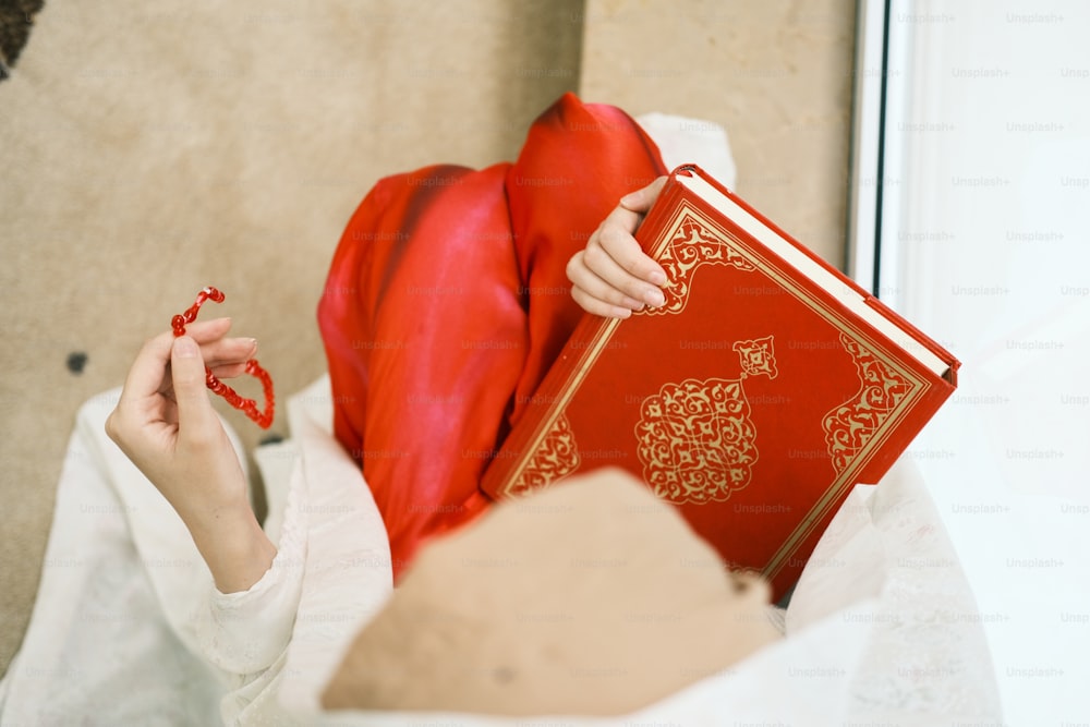 a woman holding a red book in her hands