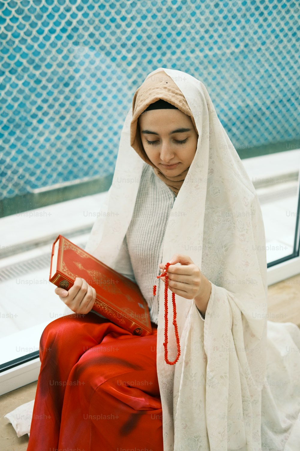 a woman sitting on the floor holding a book