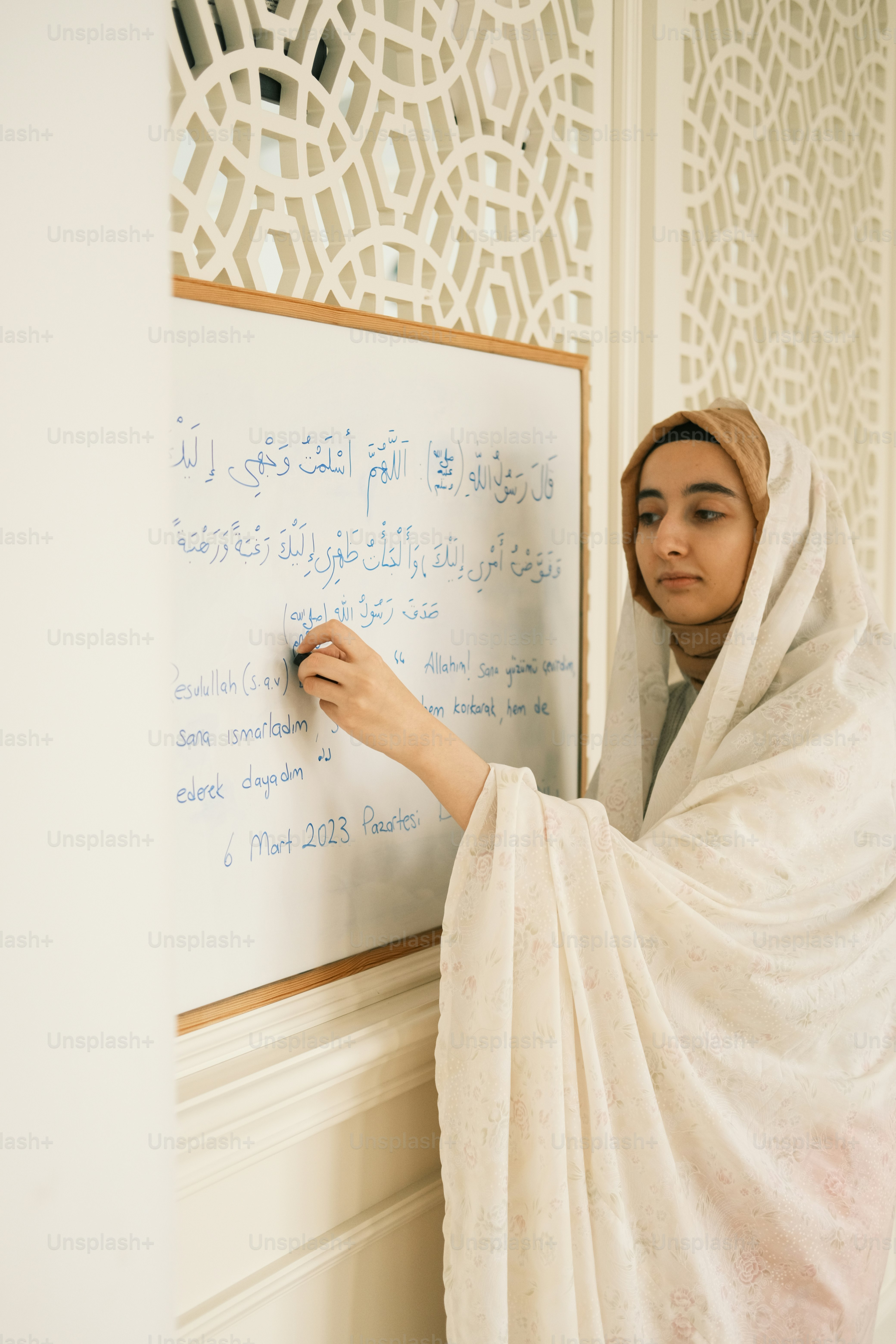 a woman is writing on a white board