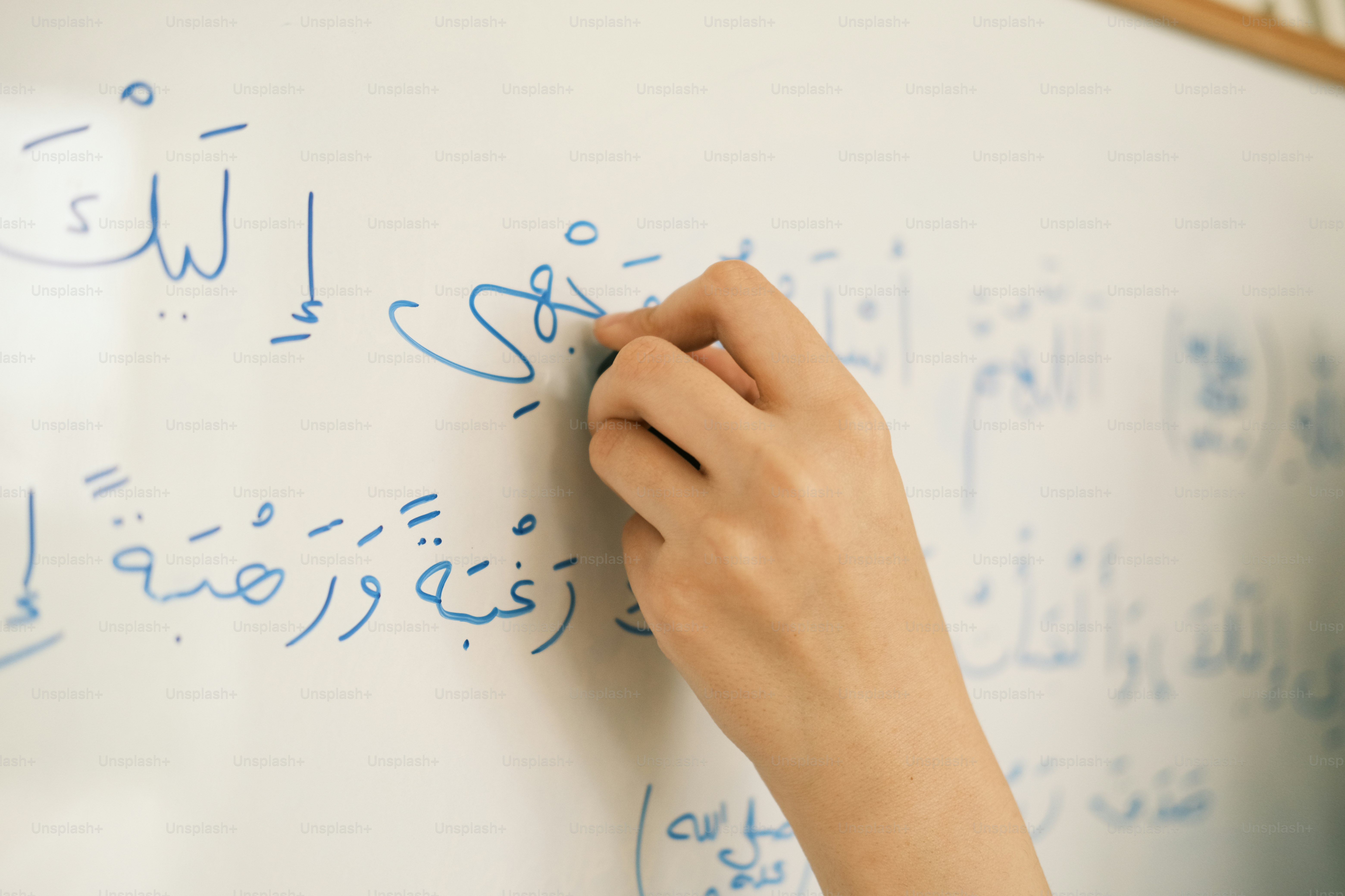 a person writing on a white board with blue writing