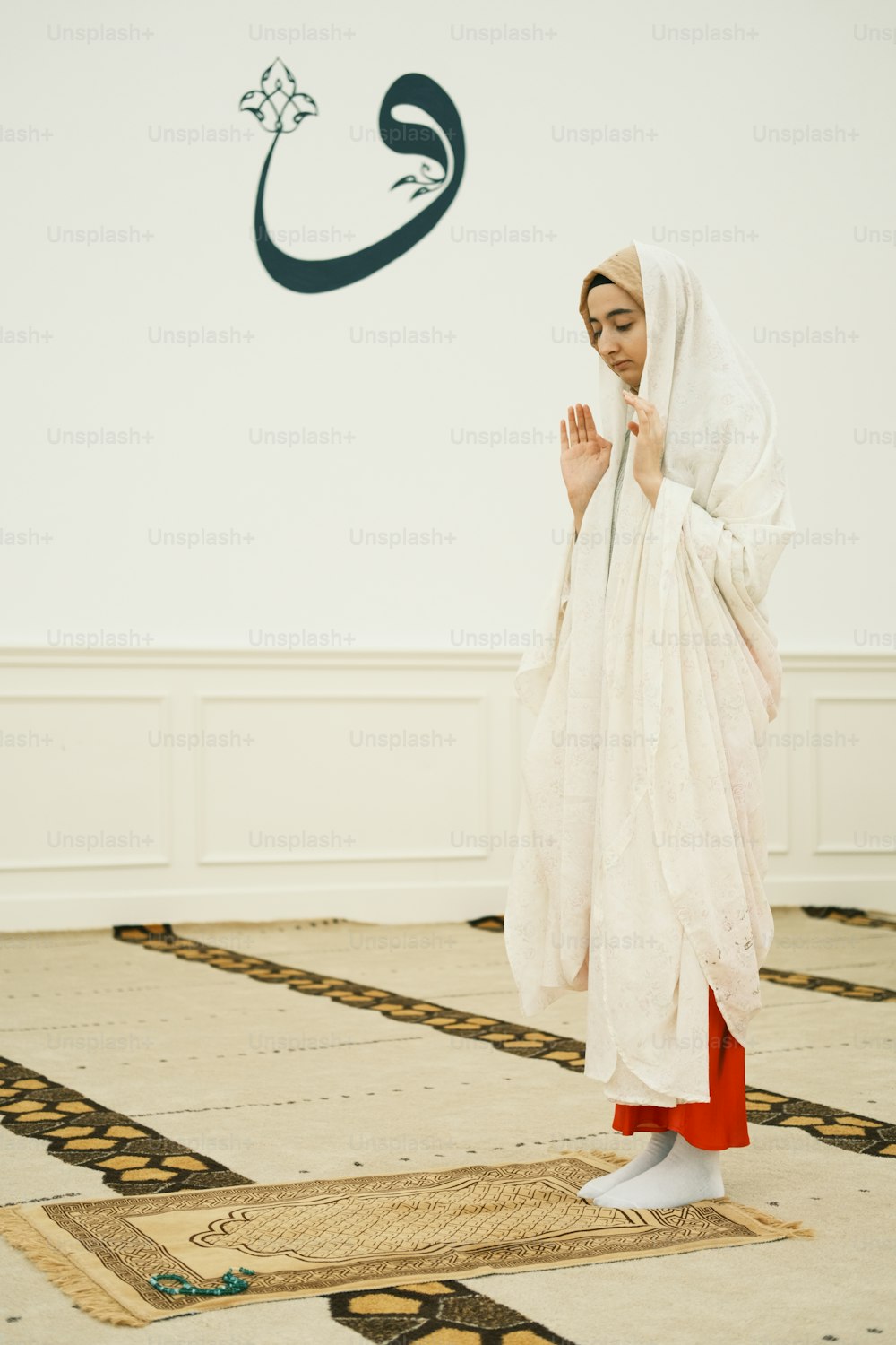 una donna in un vestito bianco in piedi su un tappeto