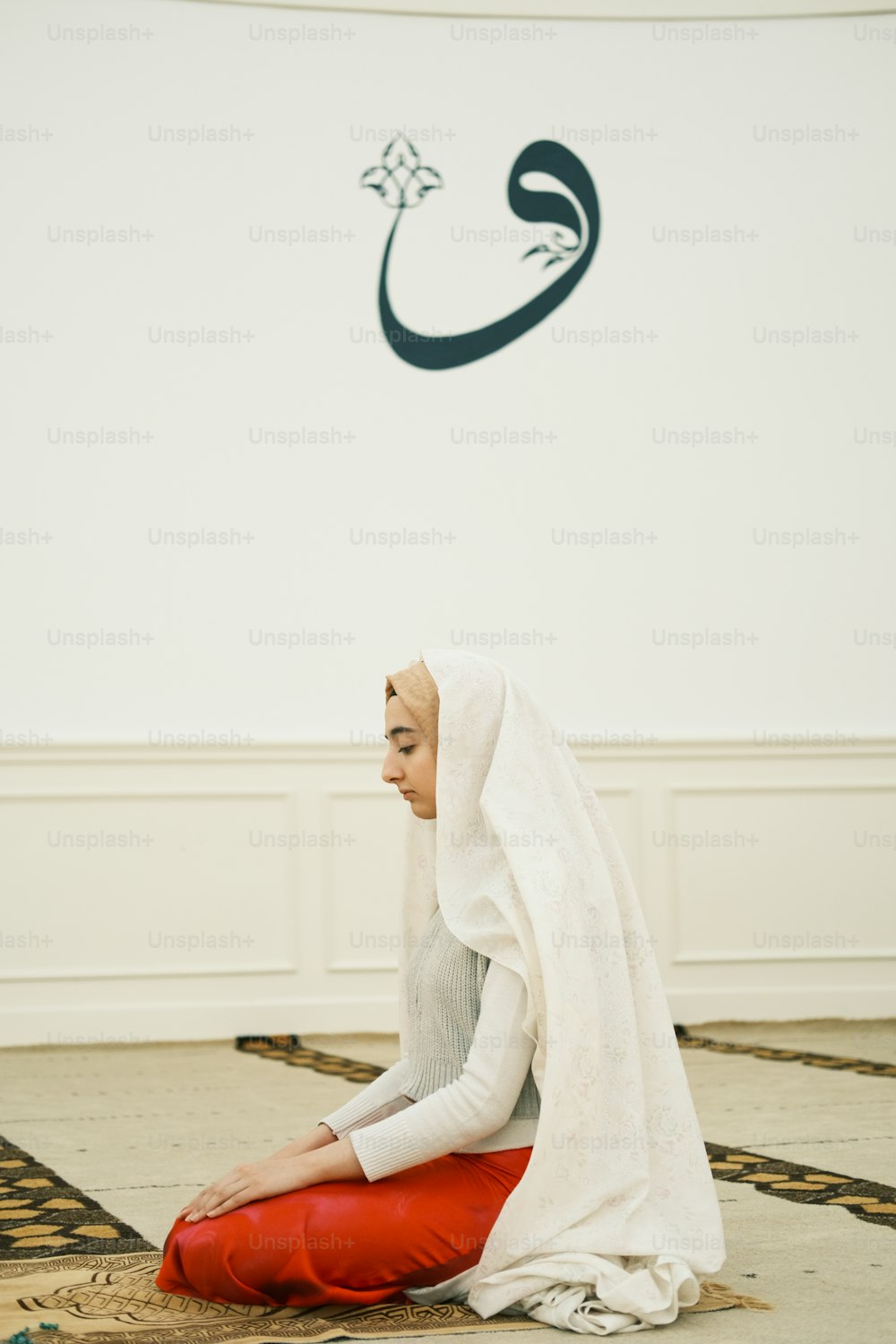 uma mulher sentada em um tapete em uma sala