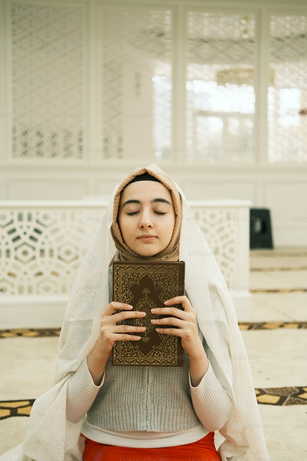 Una donna in un velo che regge un libro