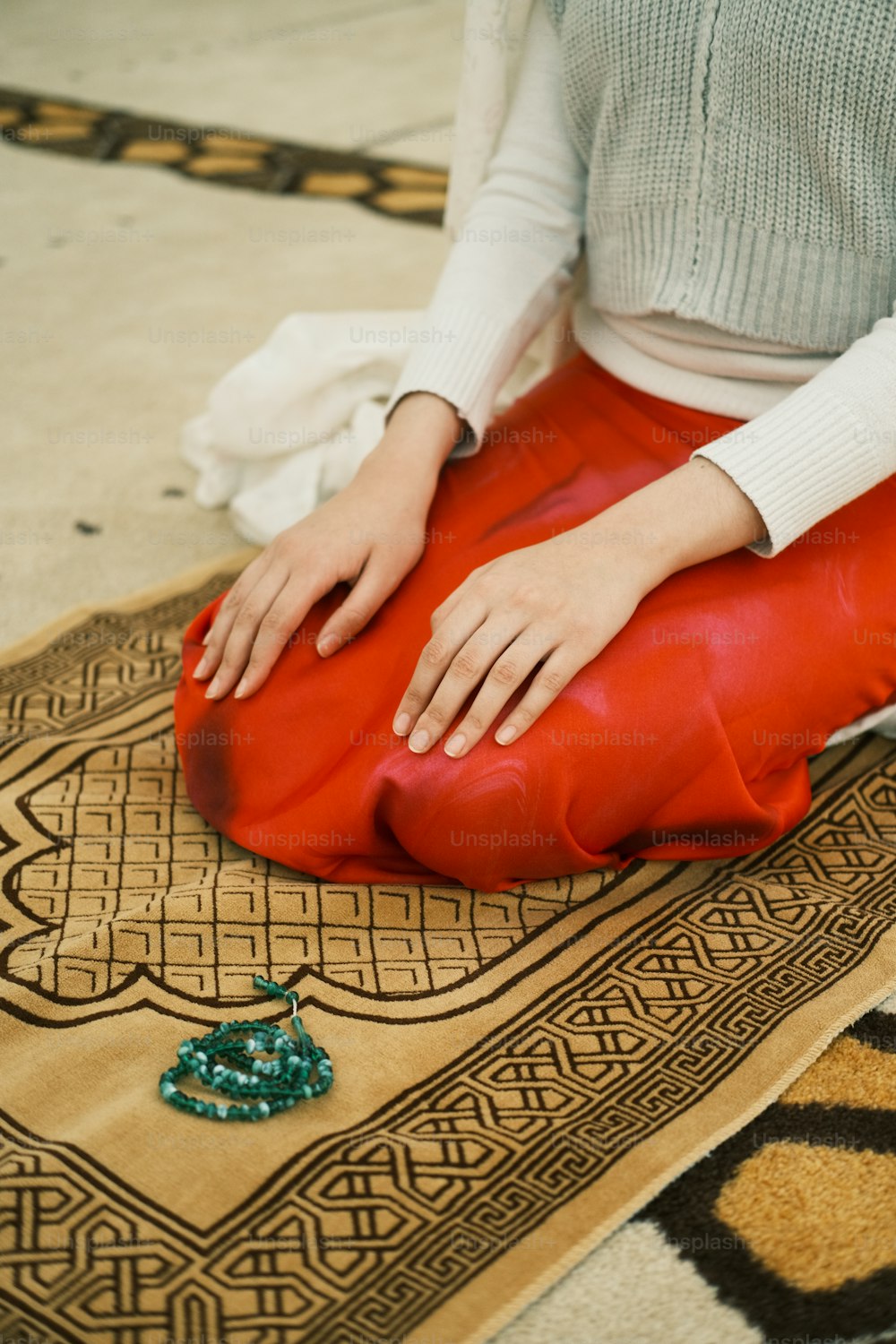 eine Frau, die auf einem Teppich auf dem Boden sitzt