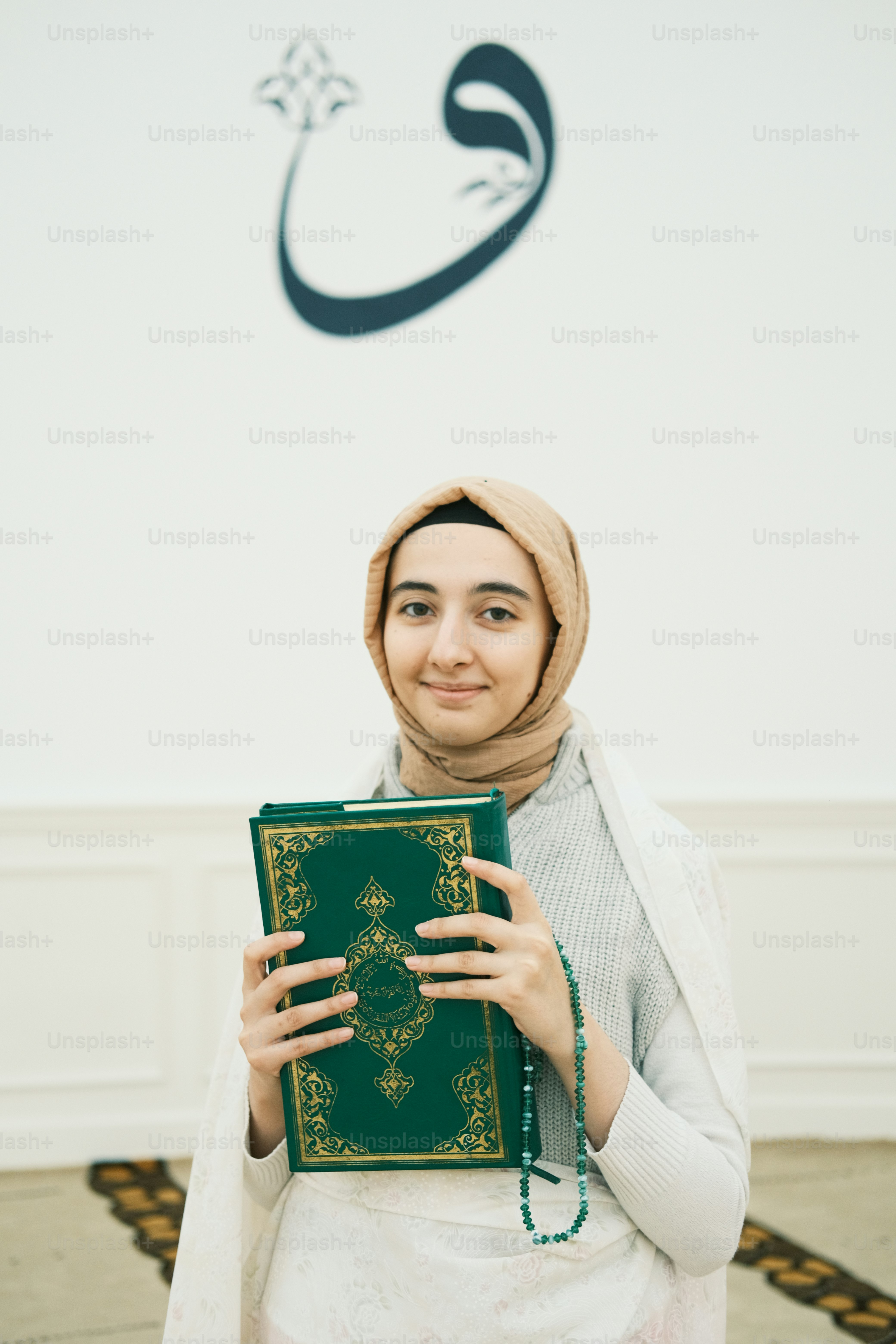 Seorang wanita berjilbab memegang buku