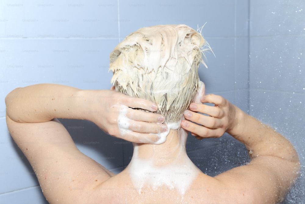 a woman is washing her hair in the shower