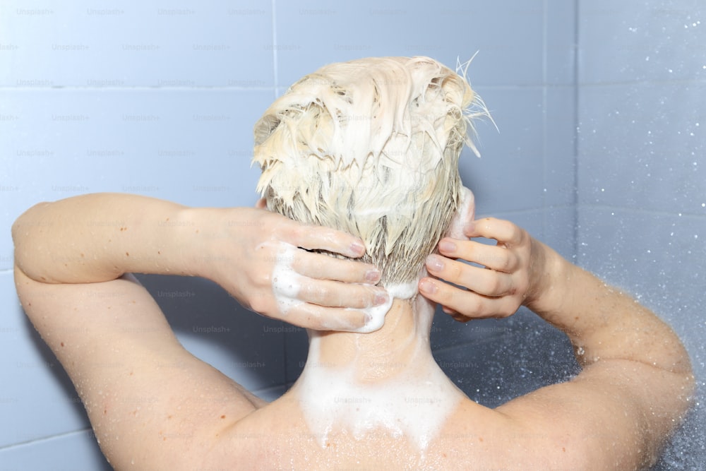 uma mulher está lavando o cabelo no chuveiro