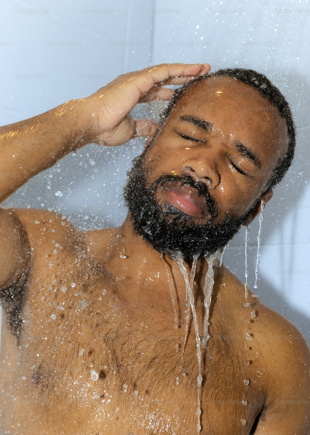 あごひげを生やした男がシャワ�ーを浴びている