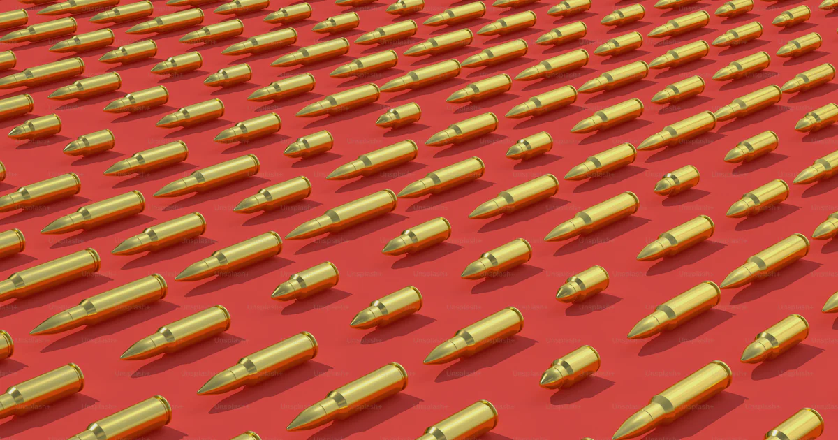 Bulleton Object A bunch of bullet like objects on a red surface photo – Bullets Image ...