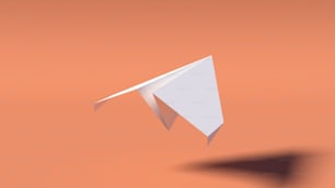 空を飛ぶ白い紙飛行機