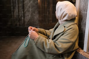 히잡을 쓴 여자가 바닥에 앉아 있다