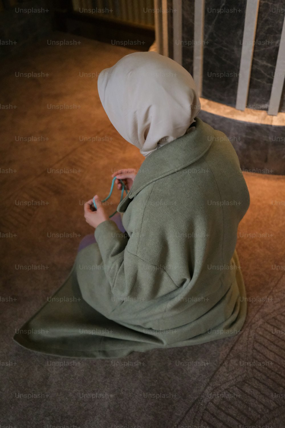 a person sitting on the floor with a hood on