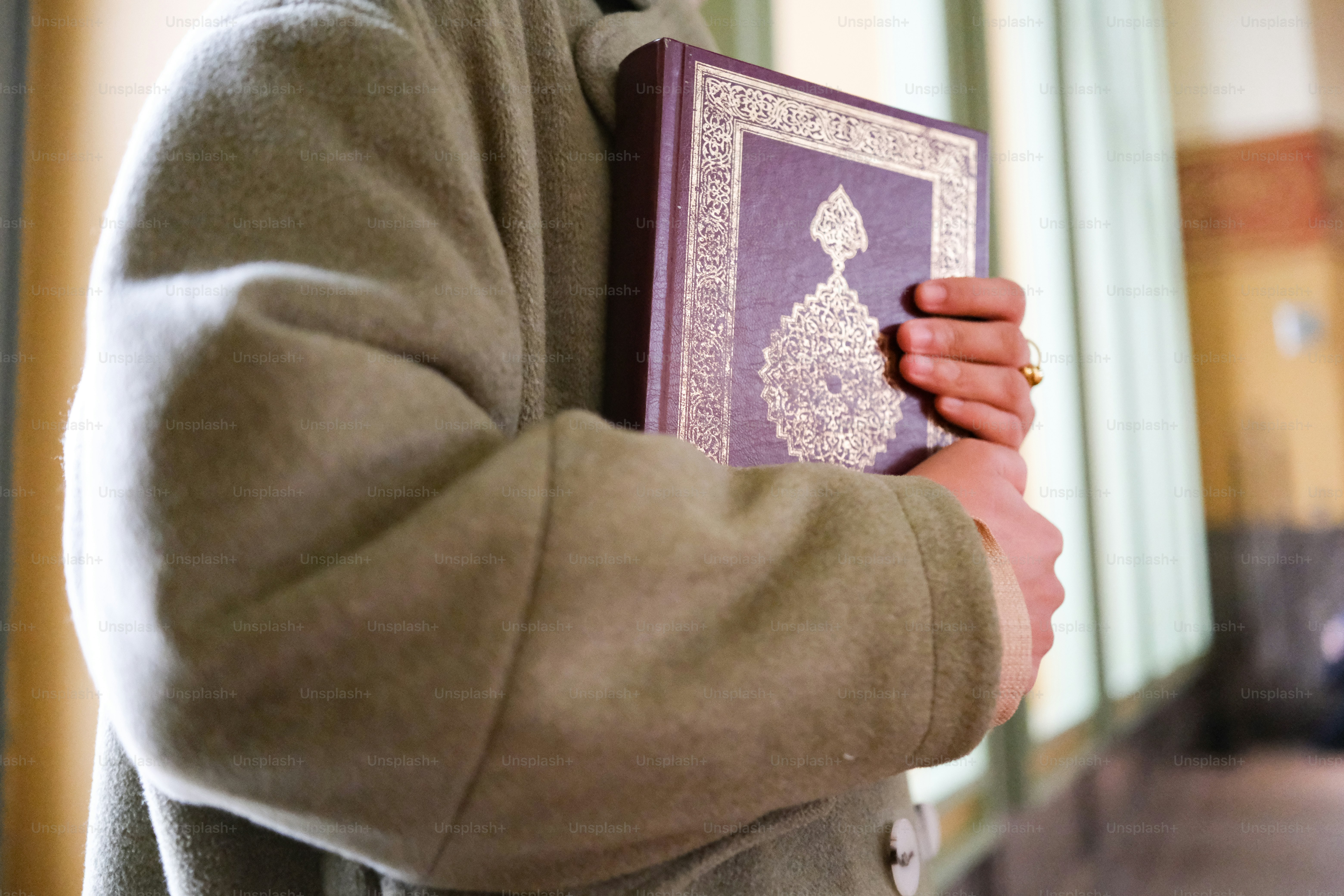 A person holding a book in their hands photo – Quran Image on Unsplash