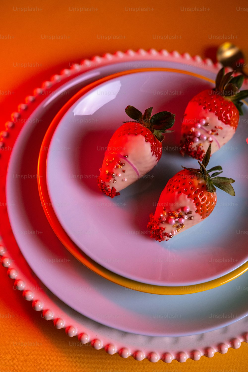 ein Teller mit drei Erdbeeren darauf