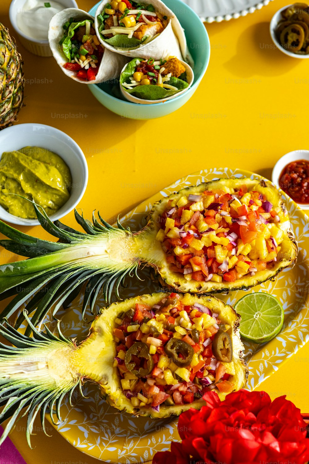a table topped with pineapples and bowls of salsa