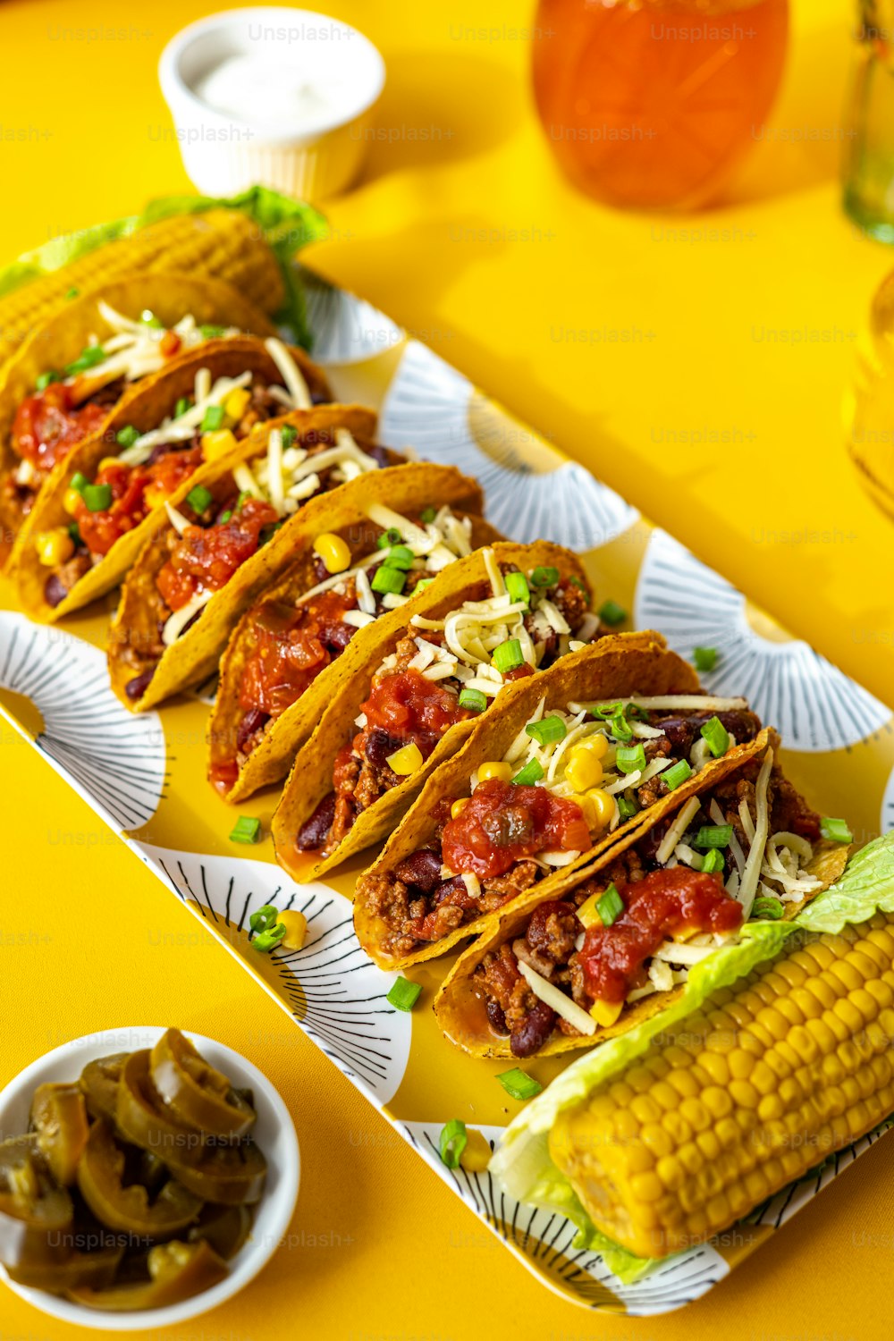a tray of tacos and corn on the cob