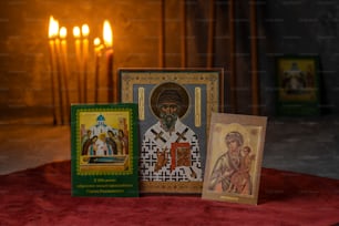 a set of three religious cards with candles in the background