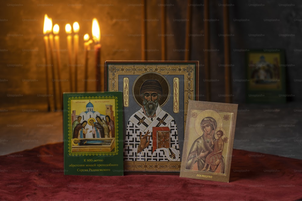 um conjunto de três cartões religiosos com velas ao fundo