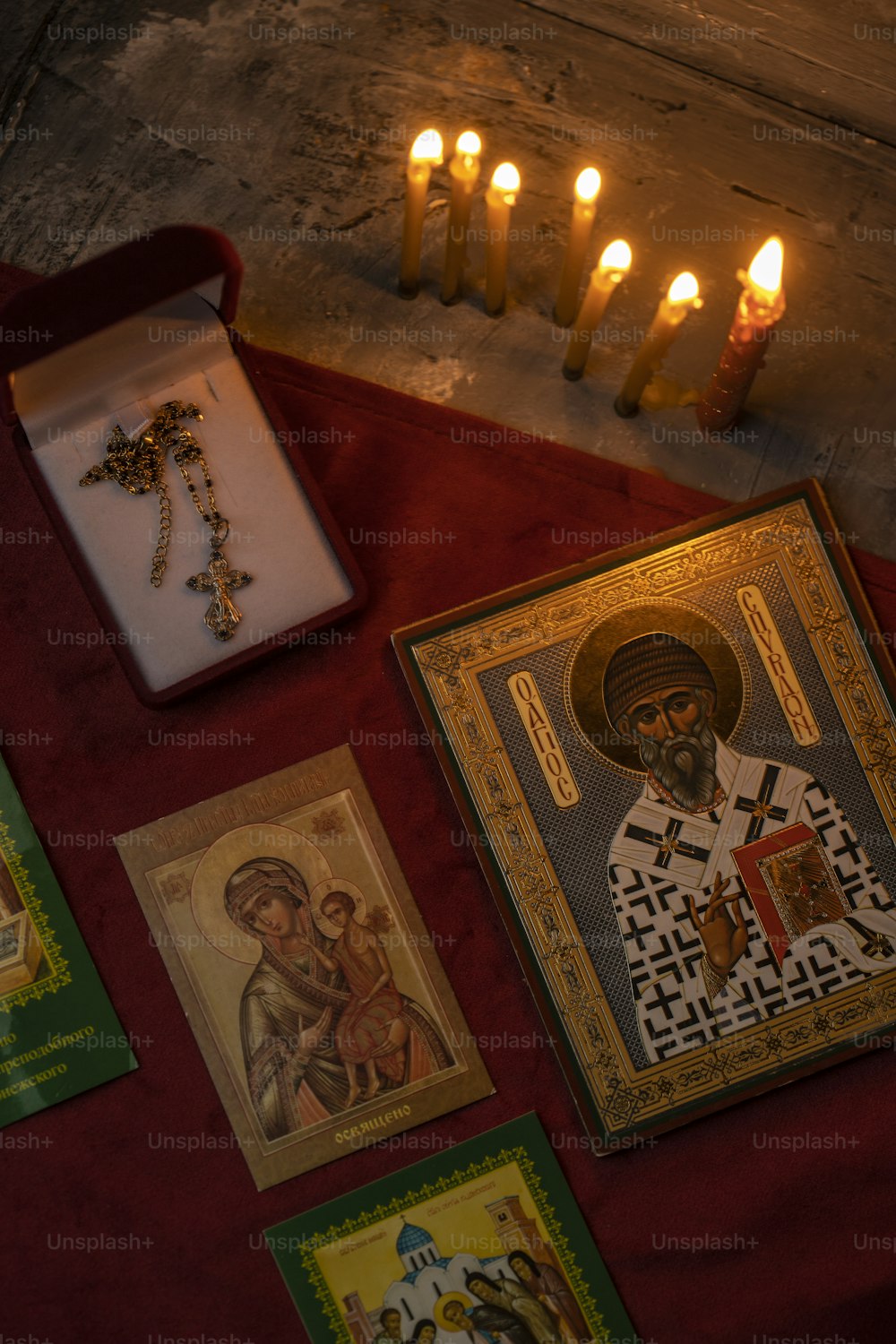 uma imagem de um padre cercado por velas